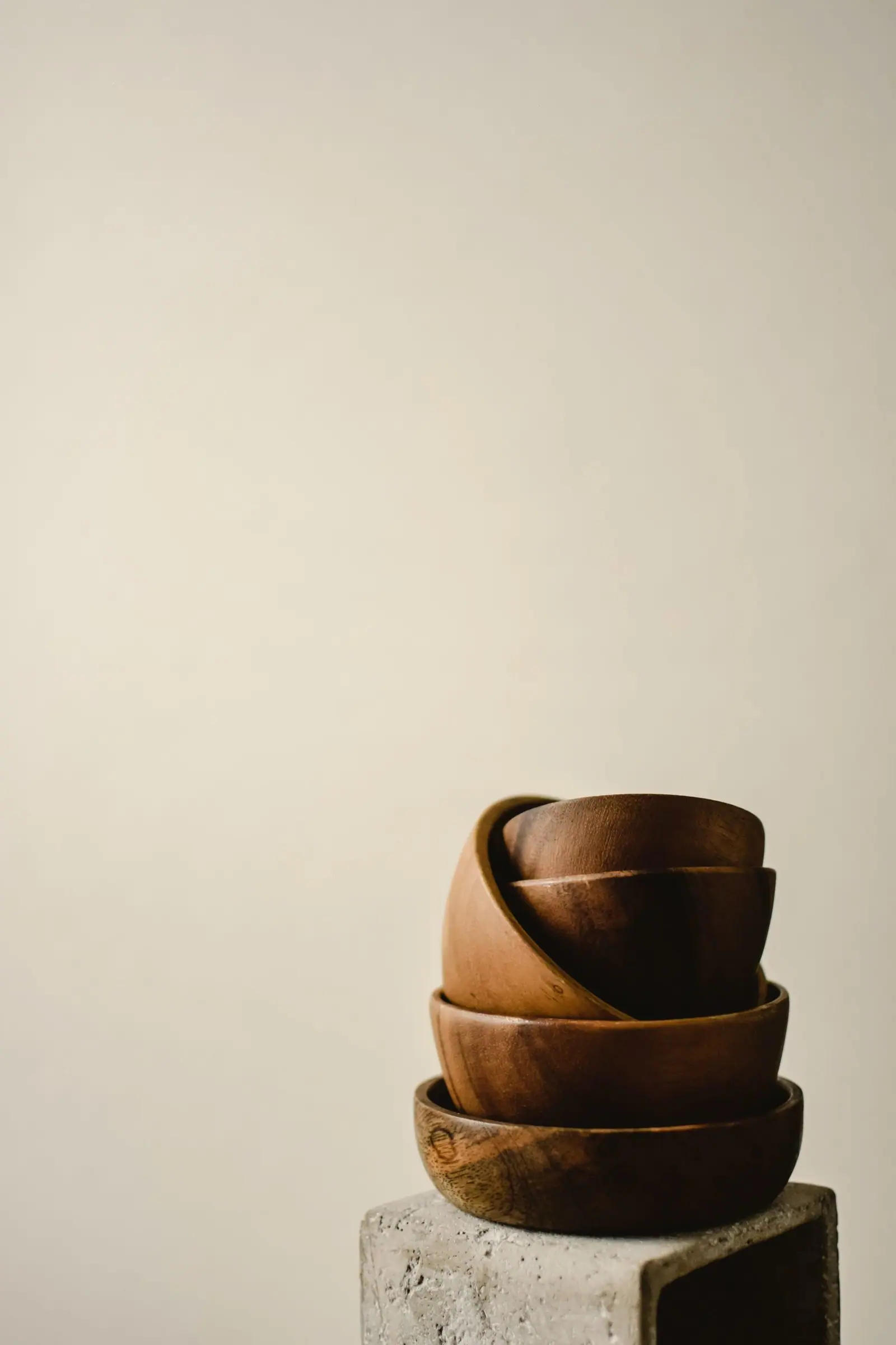 A stack of wooden bowls on a concrete plinth